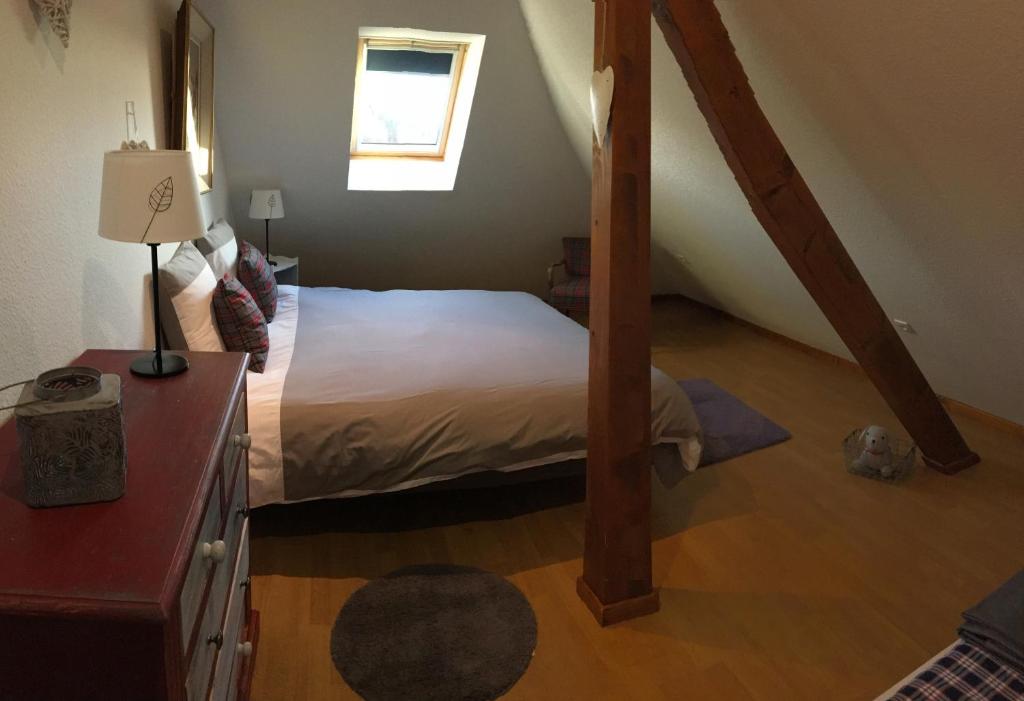 a bedroom with a bed with a wooden floor at Les appartements d'estelle in La Petite-Pierre