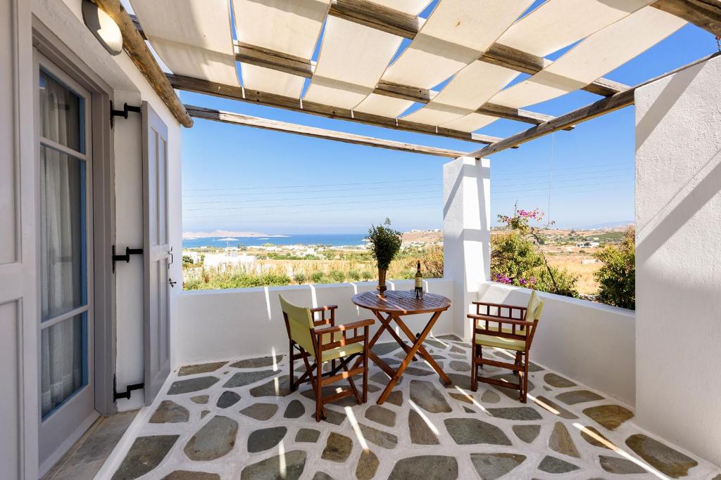 a patio with a table and chairs on a balcony at Agnanti Studios in Naousa