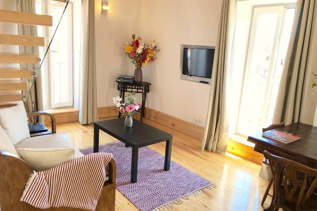 een woonkamer met een tafel en een televisie bij Center of Lisbon Duplex Apartment, Barrio Alto in Lissabon