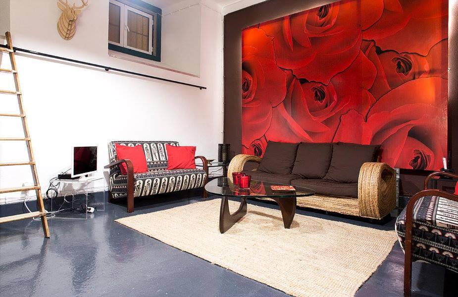 ein Wohnzimmer mit einem Sofa und einem roten Gemälde in der Unterkunft Renewed Apartment in Alfama (near the Cathedral) in Lissabon