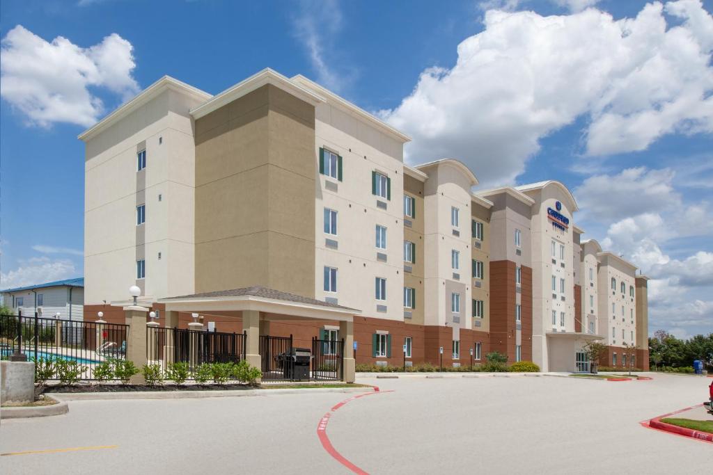 a large apartment building with a parking lot at Candlewood Suites Houston - Spring by IHG in Houston
