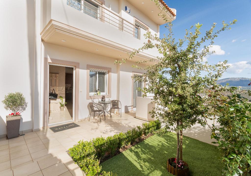 ein weißes Haus mit einem Baum im Hof in der Unterkunft MiLo Luxury House -Free Airport pick up-10min drive in Markopoulo