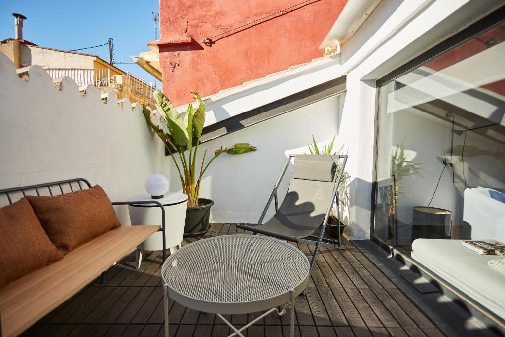 einen Balkon mit einem Sofa und einem Tisch in der Unterkunft Bubusuites in Valencia