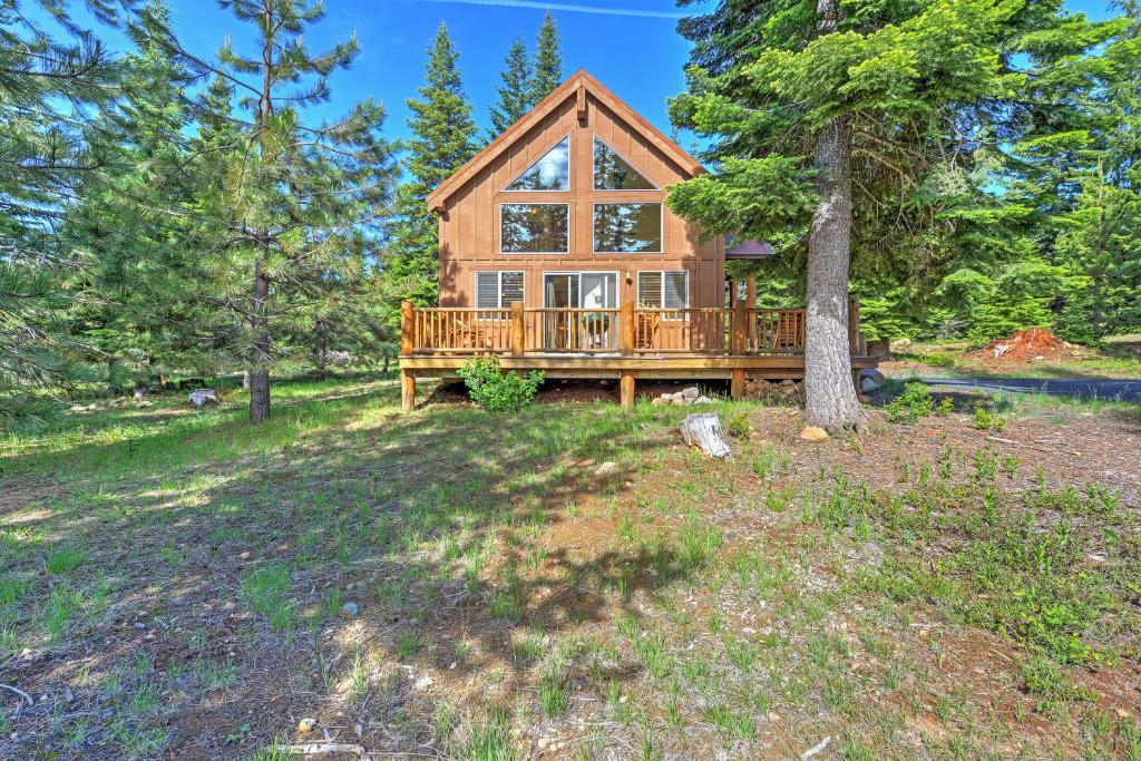 una baita di tronchi nel bosco con un albero di Bright Klamath Falls Cabin with Deck and Mtn Views! a Klamath Falls