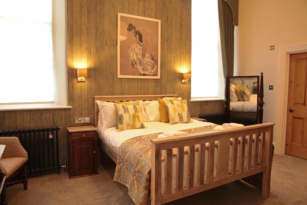 a bedroom with a large bed in a room with windows at Y Capel Guest House in Conwy