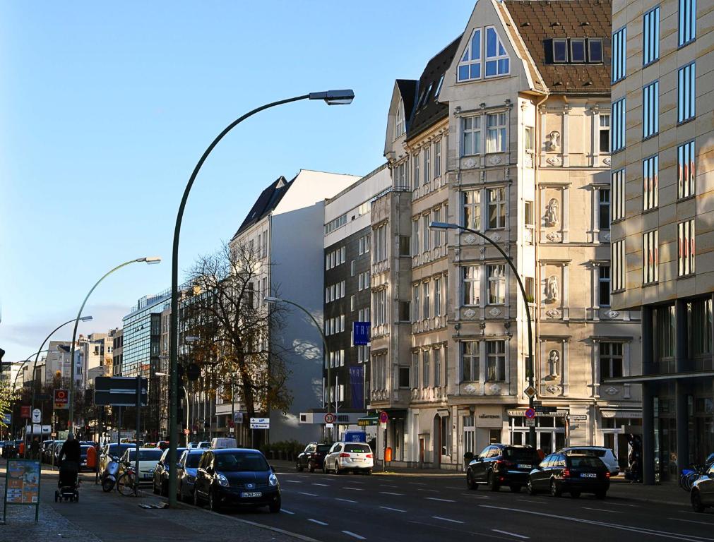 una concurrida calle de la ciudad con coches aparcados en la calle en Hotel-Pension Charlottenburg, en Berlín