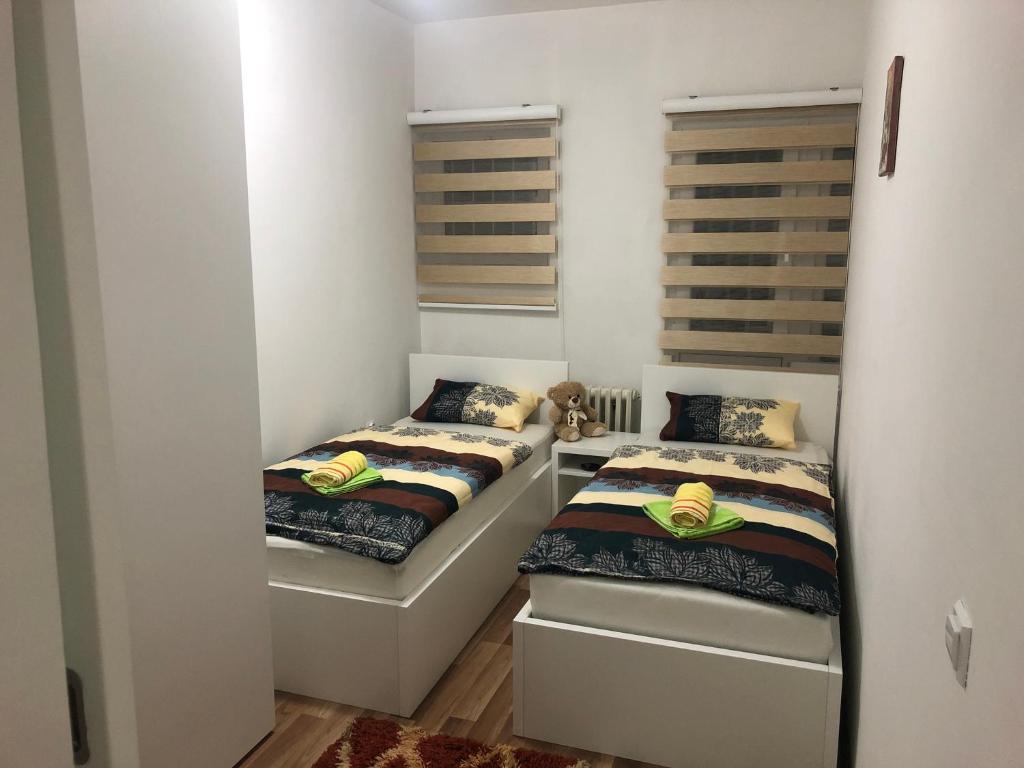 two beds in a room with white walls at Apartman Meka in Sarajevo