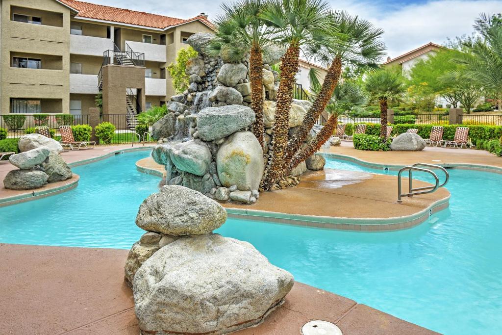 a swimming pool with a rock fountain in a resort at Las Vegas Condo with Patio, Pool, Gym about 1 Mi to Strip in Las Vegas