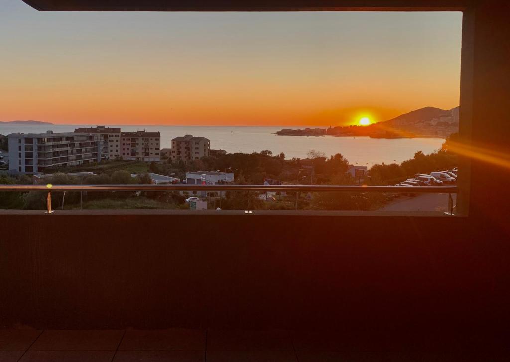 a view of the sunset from the balcony of a building at T2 Ajaccio vue mer in Ajaccio