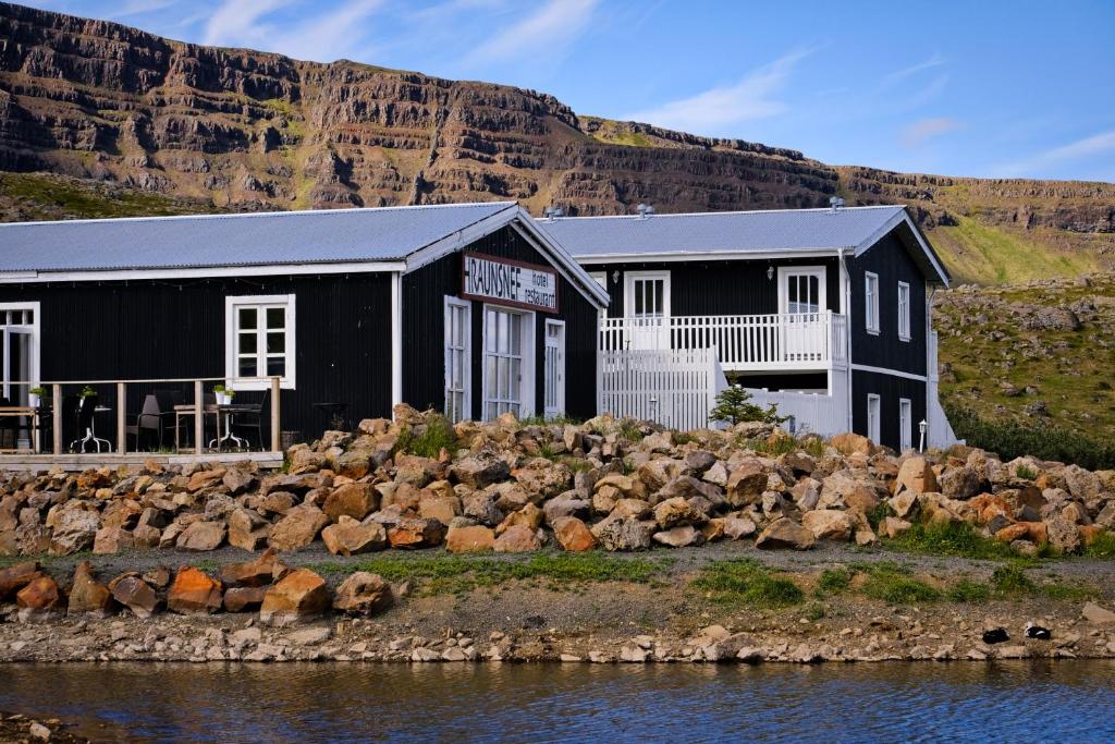 a black building next to a body of water at Hraunsnef Country Hotel in Bifrost