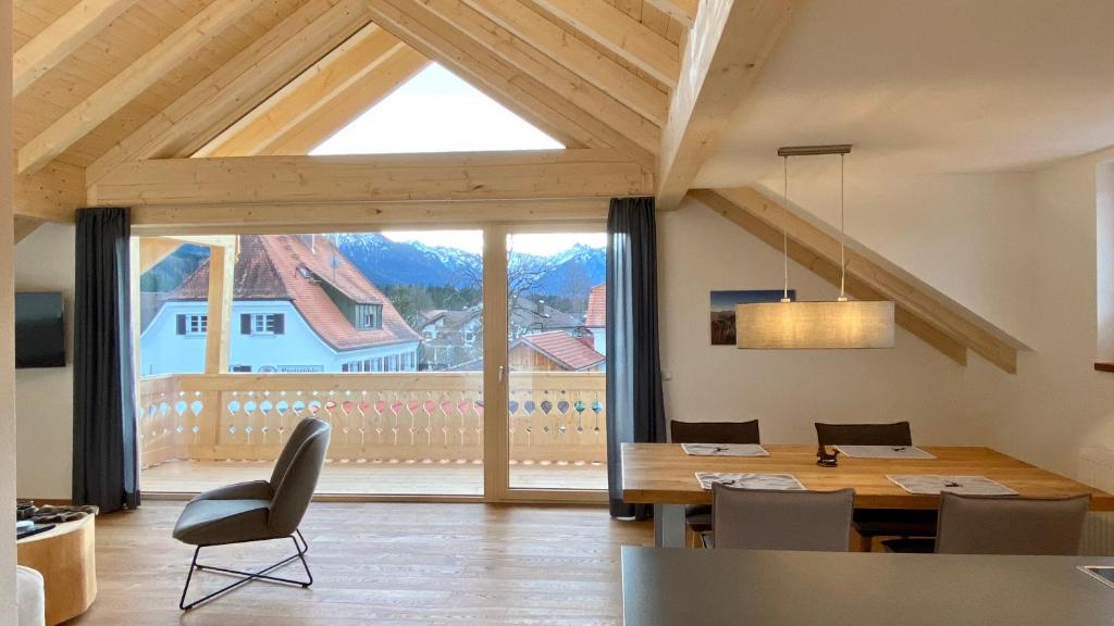 a dining room with a table and a large window at Haus Akelei in Fischen