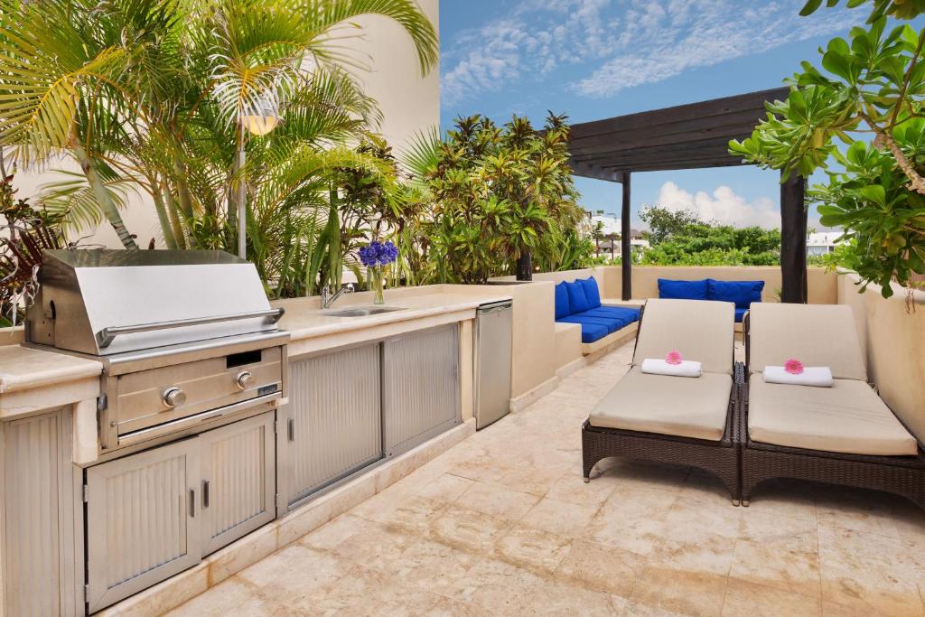 an outdoor kitchen with two chairs and a table at El Taj Oceanfront and Beachside Condo Hotel in Playa del Carmen