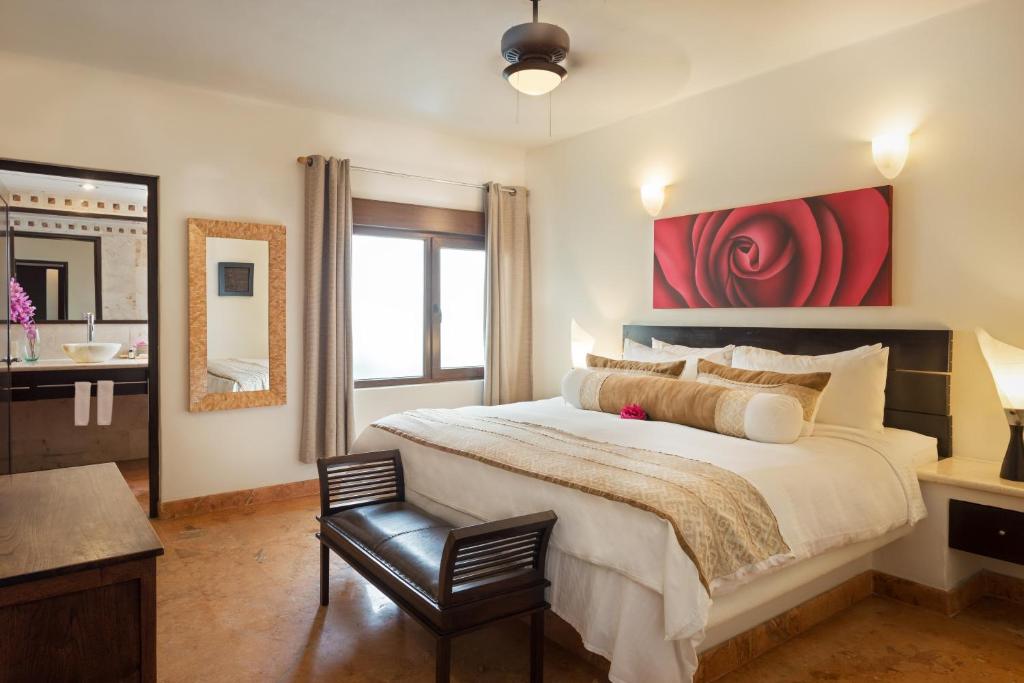a bedroom with a large bed with a red painting at El Taj Oceanfront and Beachside Condo Hotel in Playa del Carmen