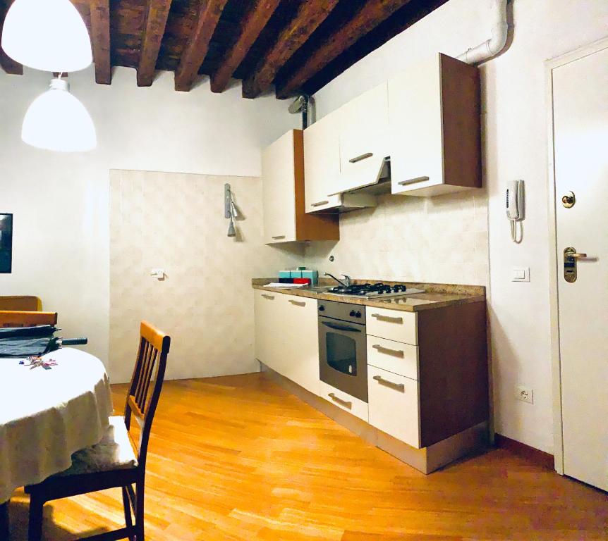a kitchen with white cabinets and a stove top oven at Furlani house 6 in Venice