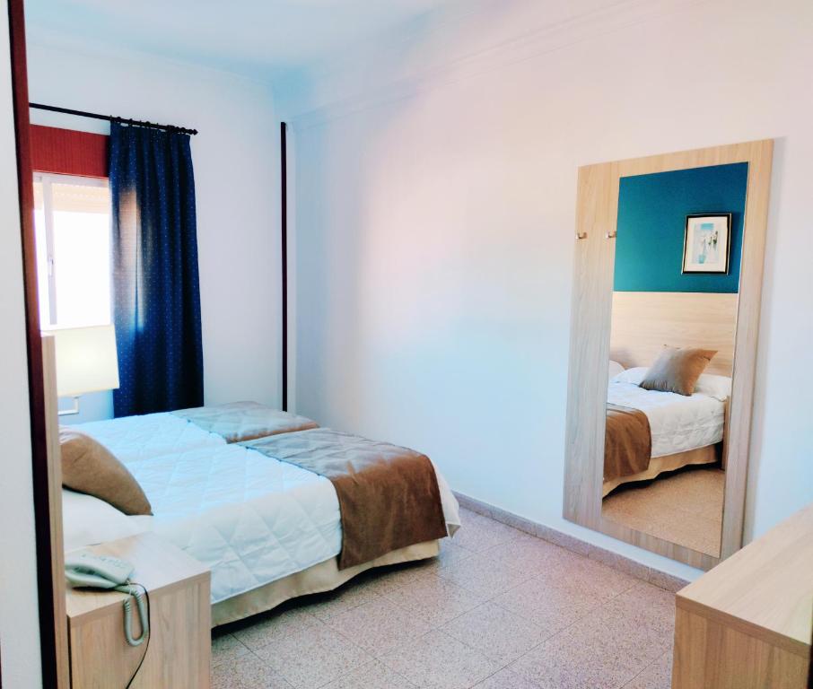 a bedroom with a bed and a large mirror at Hotel Catalán Puerto Real in Puerto Real