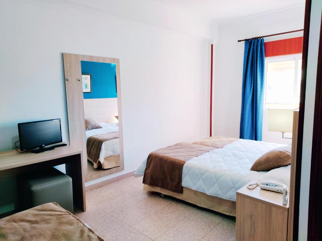 a hotel room with a bed and a mirror at Hotel Catalán Puerto Real in Puerto Real