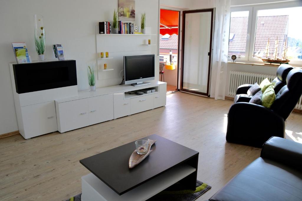 uma sala de estar com um sofá e uma televisão em Ferienwohnung Lakewinds em Meersburg