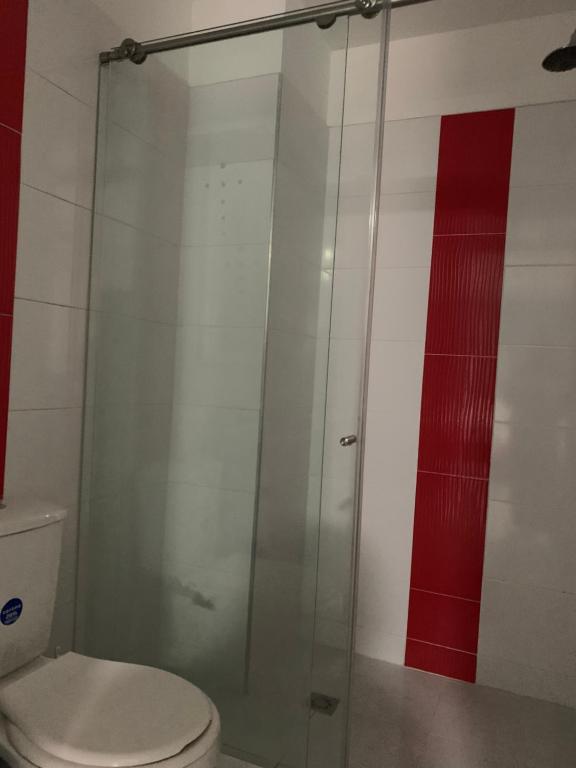 a bathroom with a glass shower with a toilet at Edificio saintjoseph in Cali
