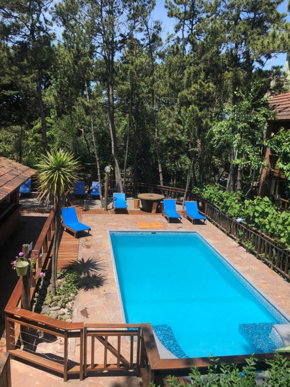 una piscina con sillas azules y una piscina en Hostería y Cabañas Altamar De Las Pampas en Mar de las Pampas