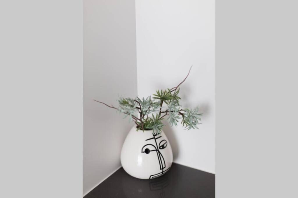 un vaso bianco seduto su un tavolo con una pianta di Wonderful Studio in Little Italy with full bath by Den Stays a Montréal