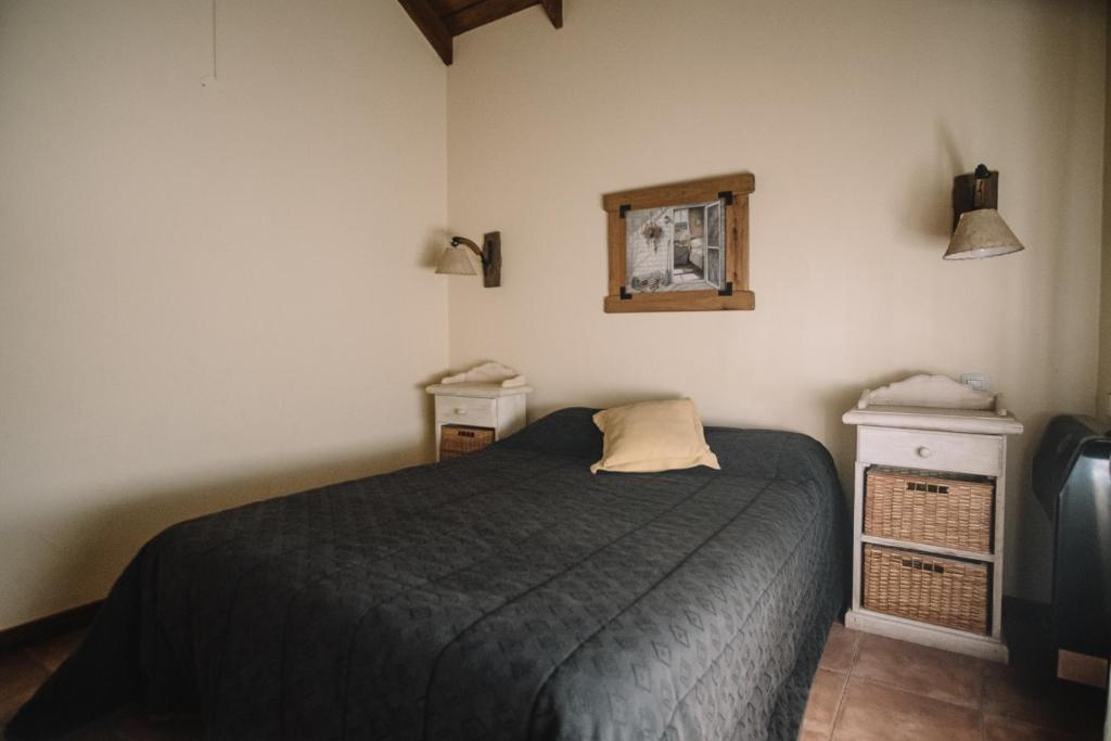 1 dormitorio con 1 cama y una foto en la pared en Las Morenas en Sierra de la Ventana