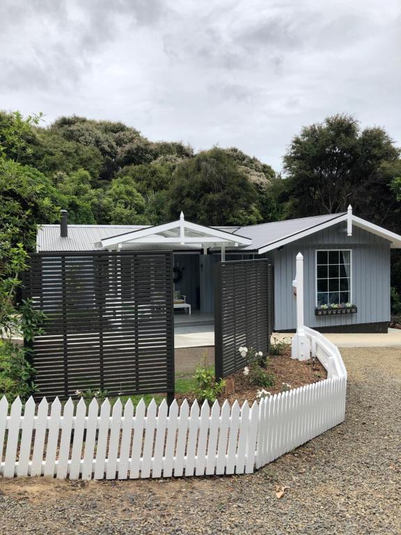 a small house with a white picket fence at Kānuka Cottage - Tranquil and relaxing in Akaroa