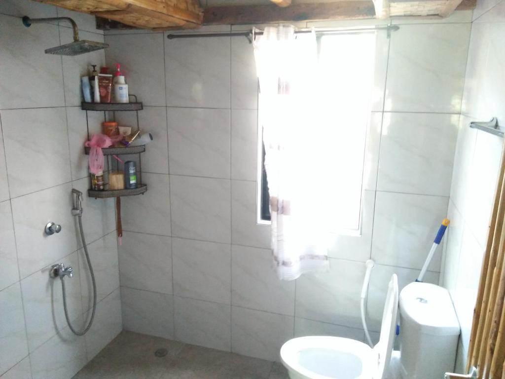 y baño con aseo y ducha. en Calayo Beach Resort en Nasugbu