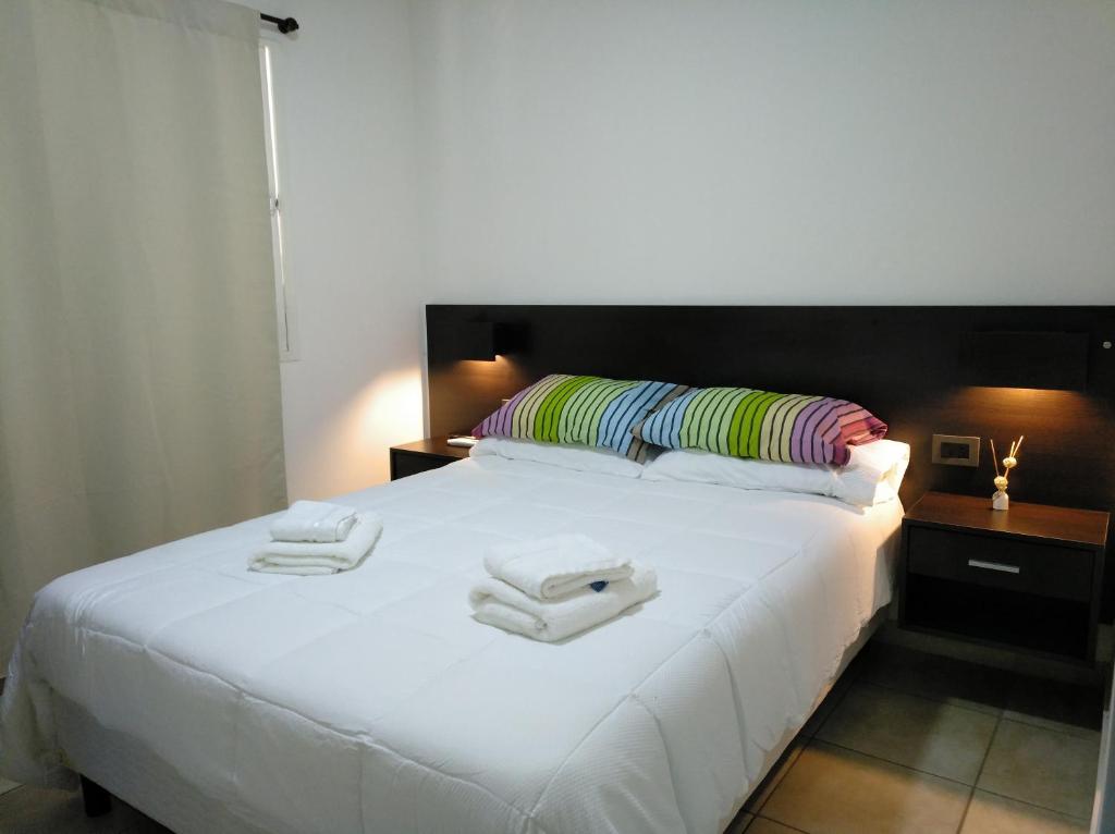 a bedroom with a white bed with towels on it at Echague y Cura A Montiel in Paraná