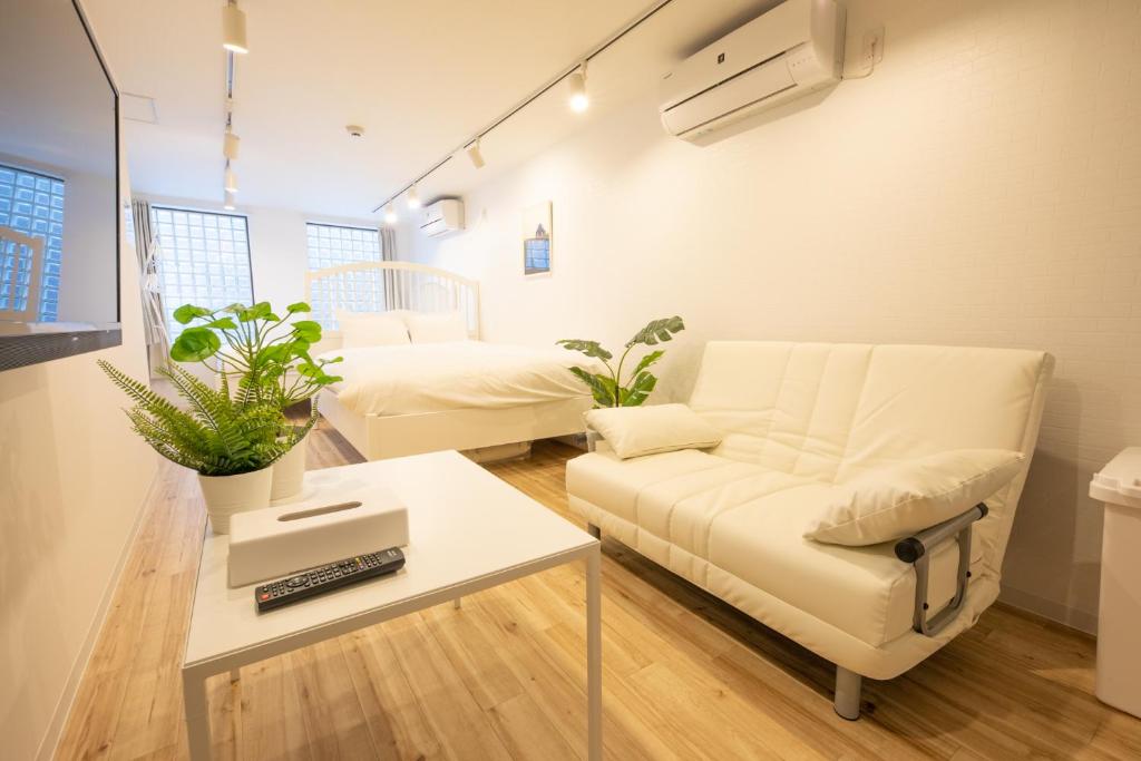 een woonkamer met een bank en een tafel bij komagome cozy room in Tokyo