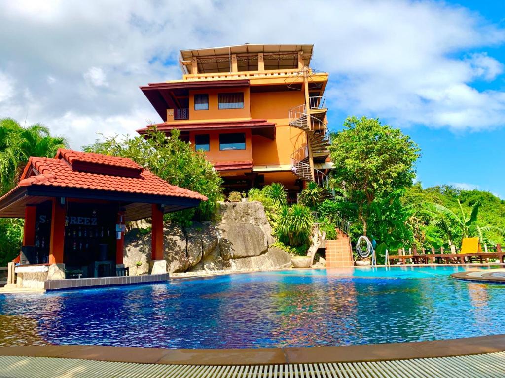 a resort with a swimming pool in front of a building at Sea Breeze Resort - SHA Plus in Haad Rin