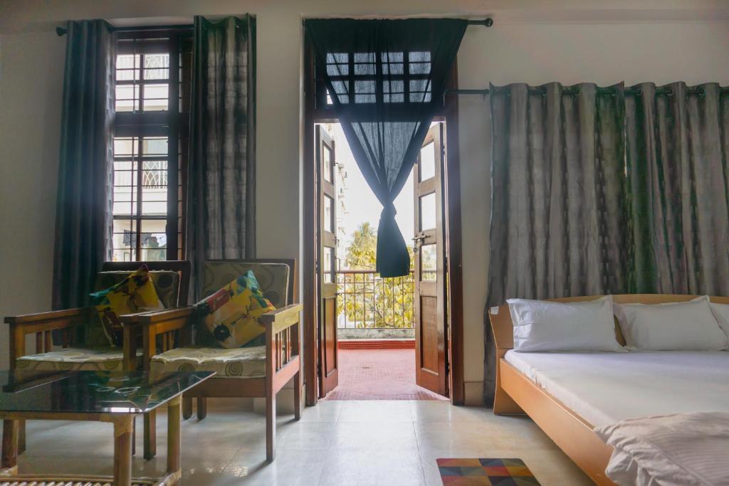 - une chambre avec un lit, une chaise et une fenêtre dans l'établissement Exotic Villa Homestay, à Guwahati