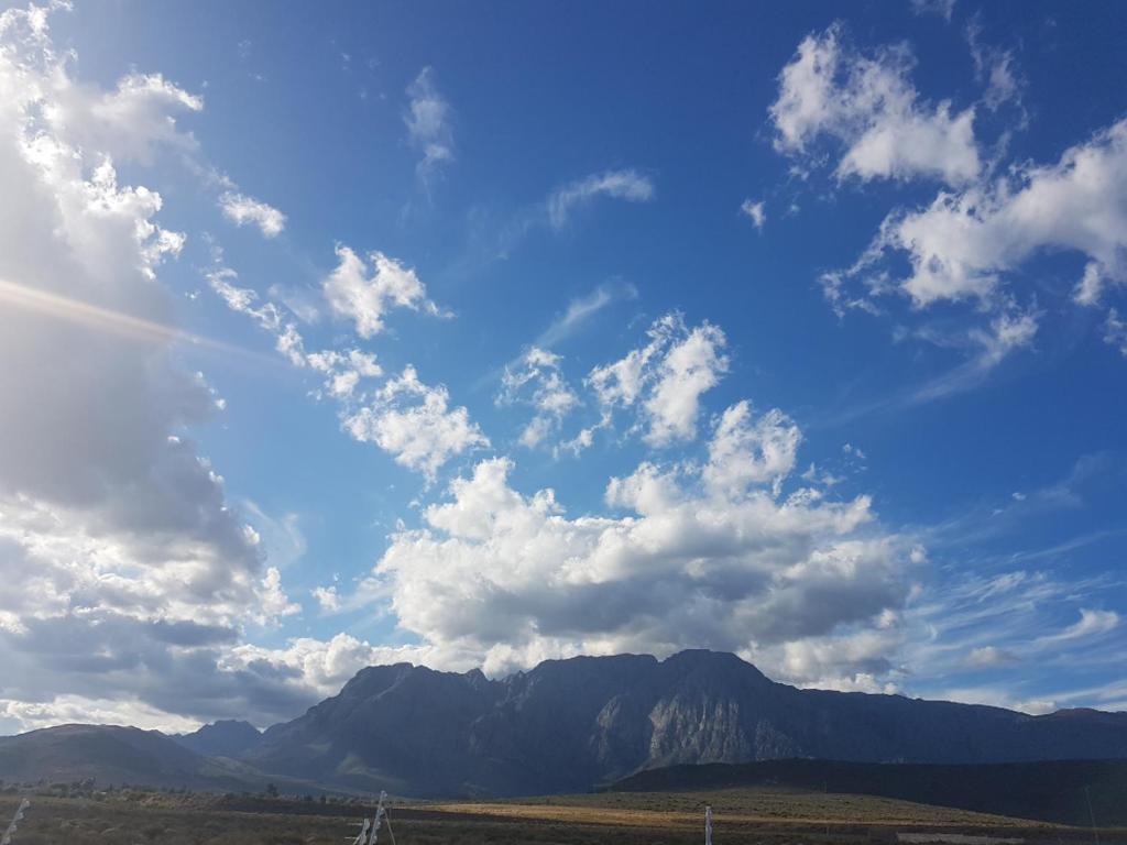 a cloudy sky with a mountain in the background at Worcester the Karoo Guest Room in Worcester