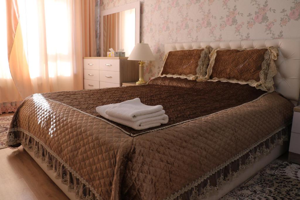 a bedroom with a bed with two towels on it at Hotel Apartment Al-Salam in Bishkek