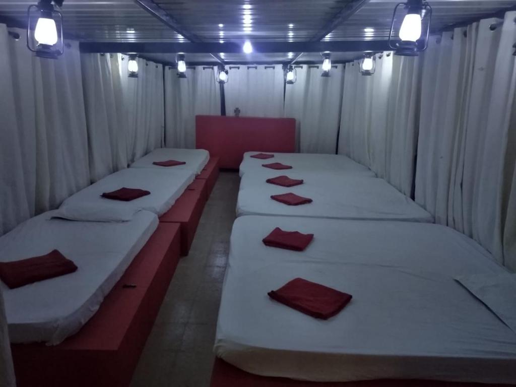 a row of beds sitting in a room with lights at Ooty Dormitories in Ooty