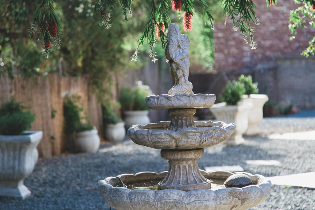 a stone fountain in the middle of a garden at The Symphony Guest House in Queenstown