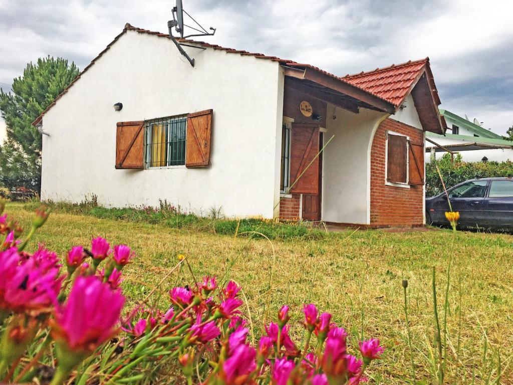 una casa vieja en un campo con flores rosas en La Susy en 