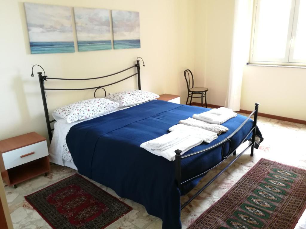カターニアにあるCasa Levante Sea View Apartmentのベッドルーム1室(ブルーベッド1台、タオル付)