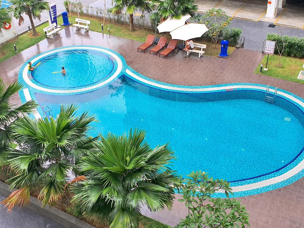 an overhead view of a large swimming pool with palm trees at KLIA Ehsan Residences Sepang Nilai in Sepang