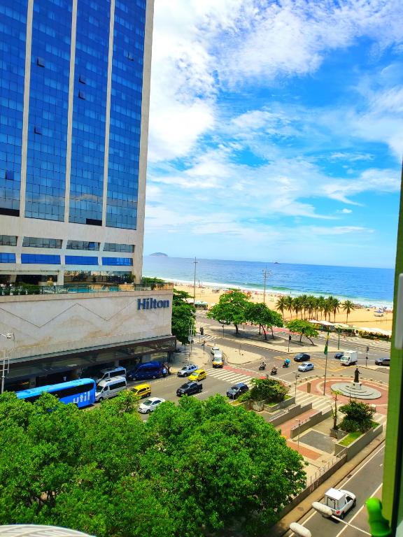 een uitzicht op een parkeerplaats met een gebouw en de oceaan bij Luxury Ocean Top Copacana in Rio de Janeiro