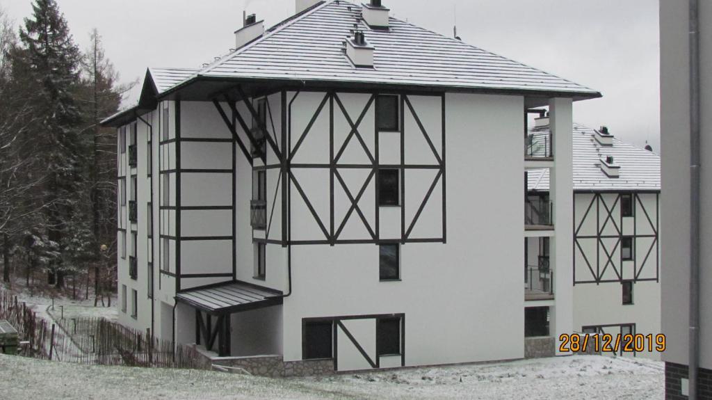 a large white building with a metal roof at Apartamenty Piano in Świeradów-Zdrój