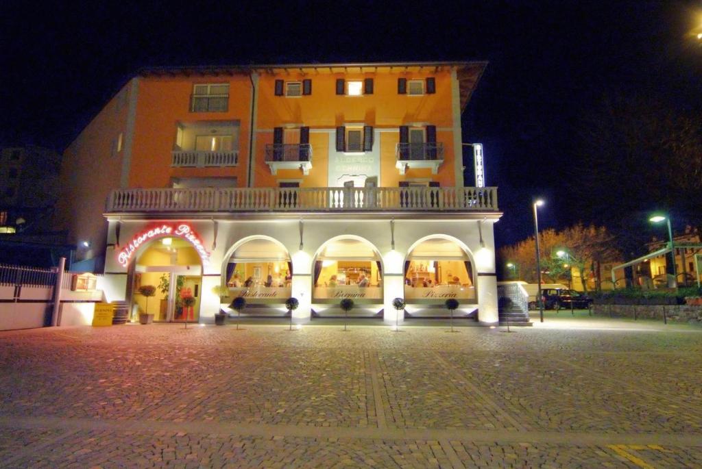 a large building at night with a building at Hotel Bernina in Tirano