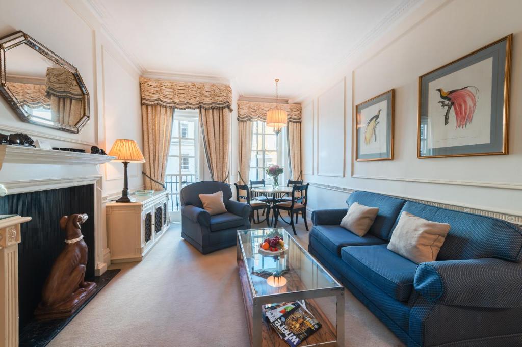 - un salon avec un canapé bleu et une table dans l'établissement 44 Curzon Street by Mansley, à Londres