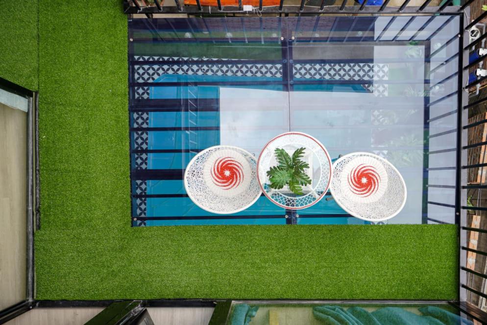a window with three hats and a swimming pool at Almor Hostel With Pool in right center in Ha Long