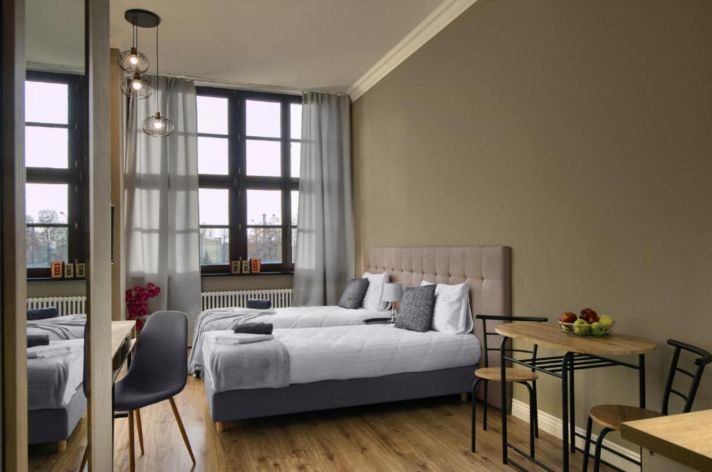 1 dormitorio con 2 camas y mesa en Apartamenty Oliwka en Elblag