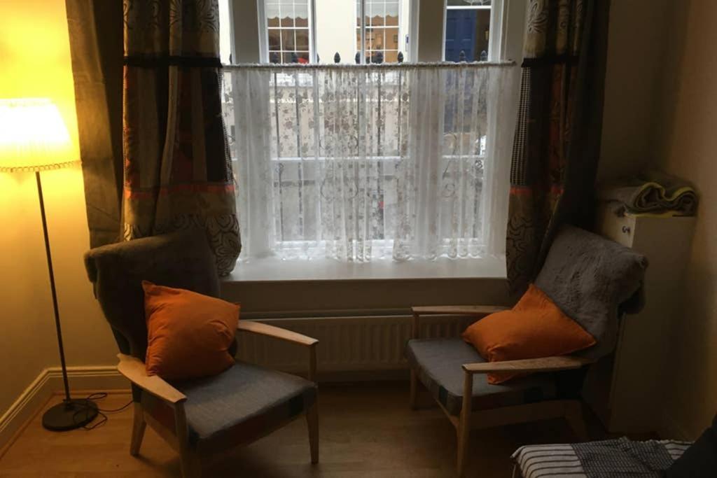 a living room with two chairs and a window at Cathedral apartment in Derry Londonderry