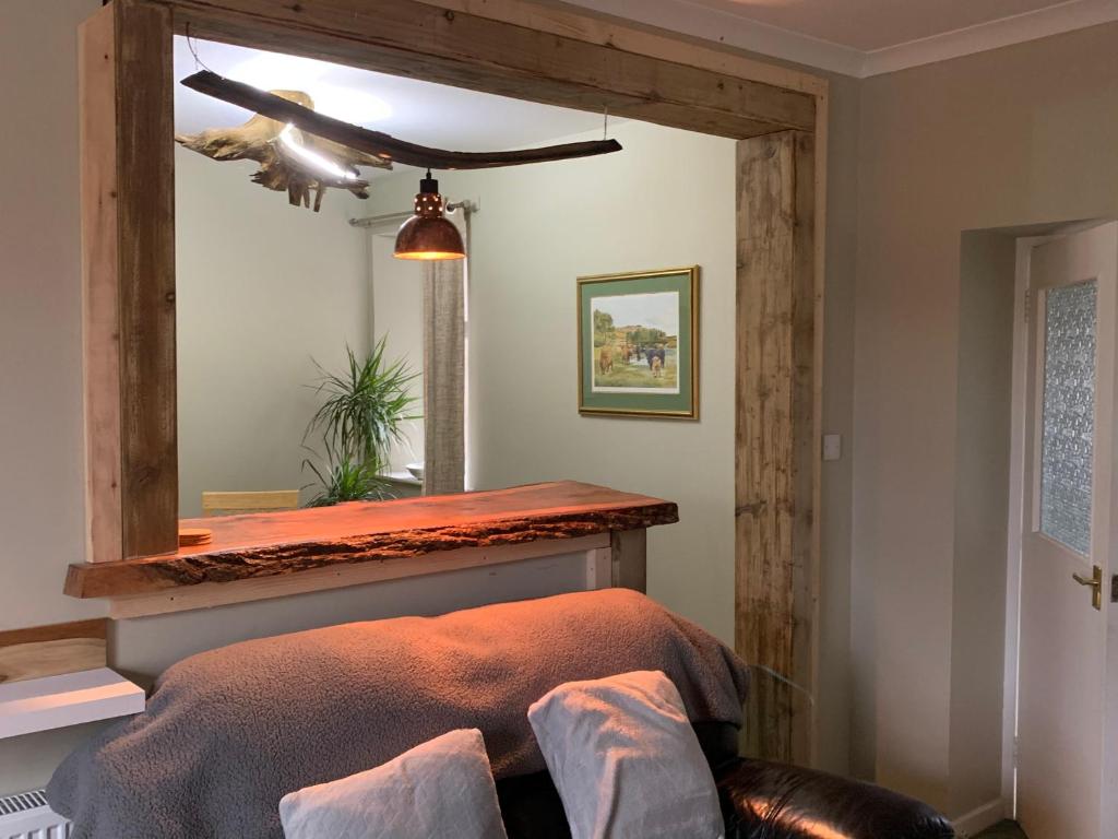 a bedroom with a bed with a mirror and a ceiling at The Cottage Aberlour in Aberlour