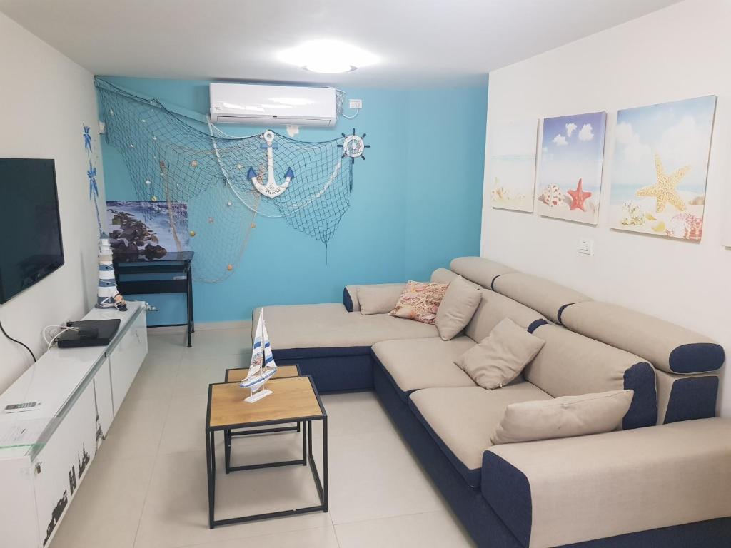 een woonkamer met een bank en een tafel bij mi casa es su casa in Ashkelon