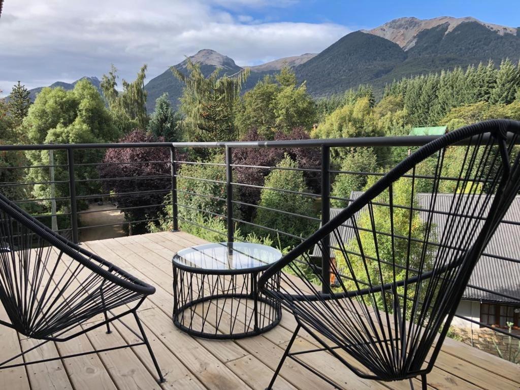 dos sillas en una terraza con montañas en el fondo en Balcones de Montaña en Villa La Angostura