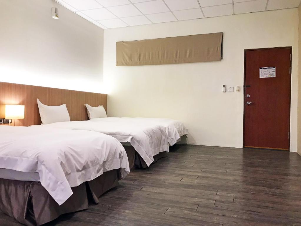 Postel nebo postele na pokoji v ubytování NCNU Campus Inn暨大行旅