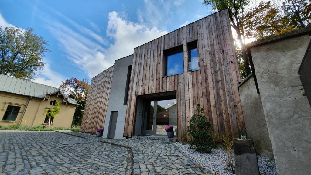 uma casa com uma fachada de madeira com uma entrada de pedra em Exclusive penzion Viva Residence em Mladá Boleslav